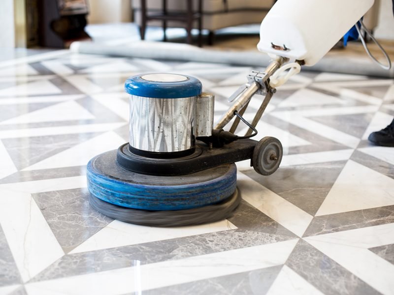 man polishing marble floor in modern office building